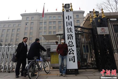 3月17日上午,一名男子在新掛牌的中國鐵路總公司牌前留影。當(dāng)日早上,原“鐵道部”牌匾被摘下,工作人員換上了“中國鐵路總公司”的新牌。中新社發(fā) 張浩 攝